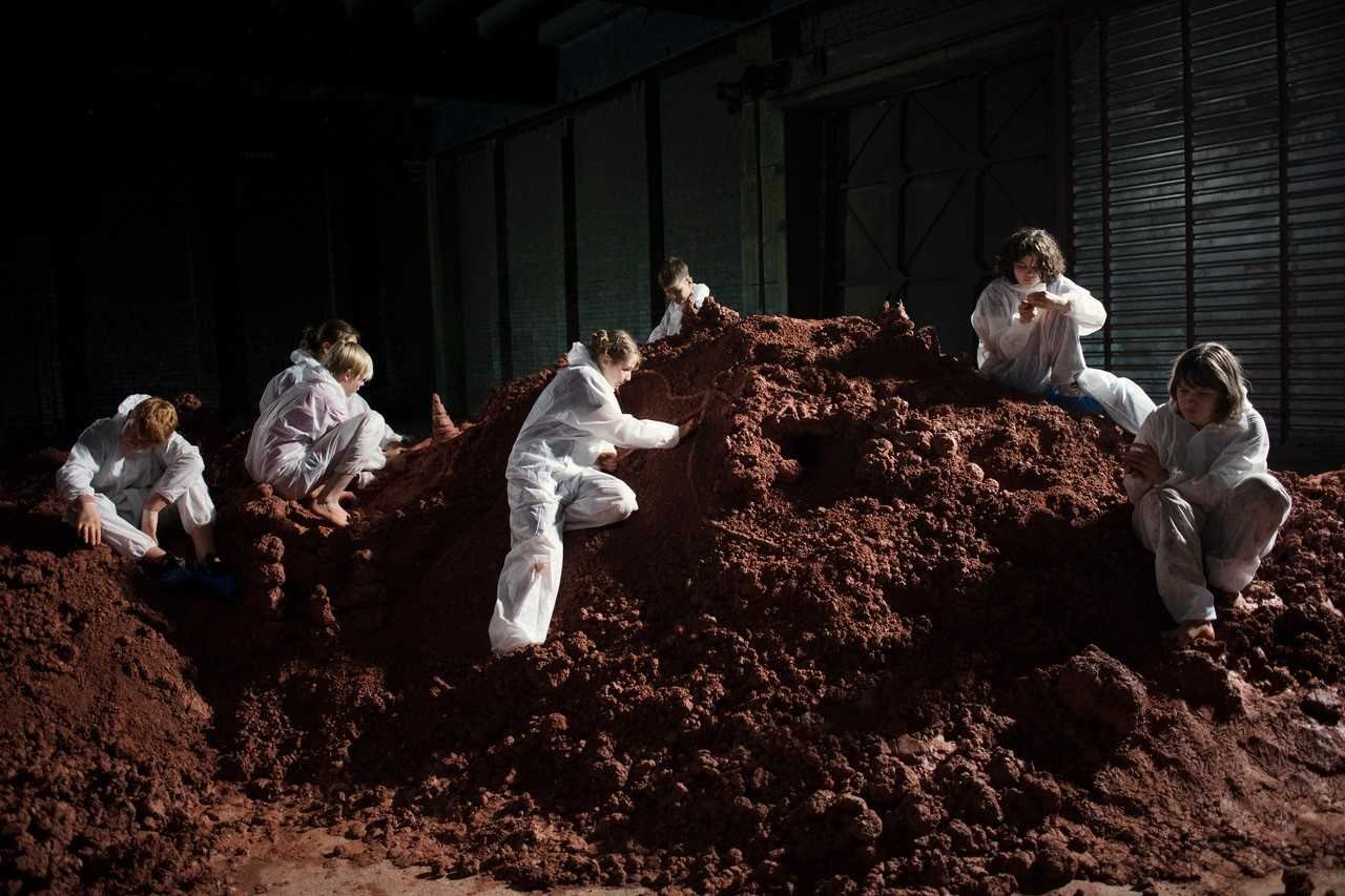 Frauen mit weißen Overalls auf einem Berg Erde