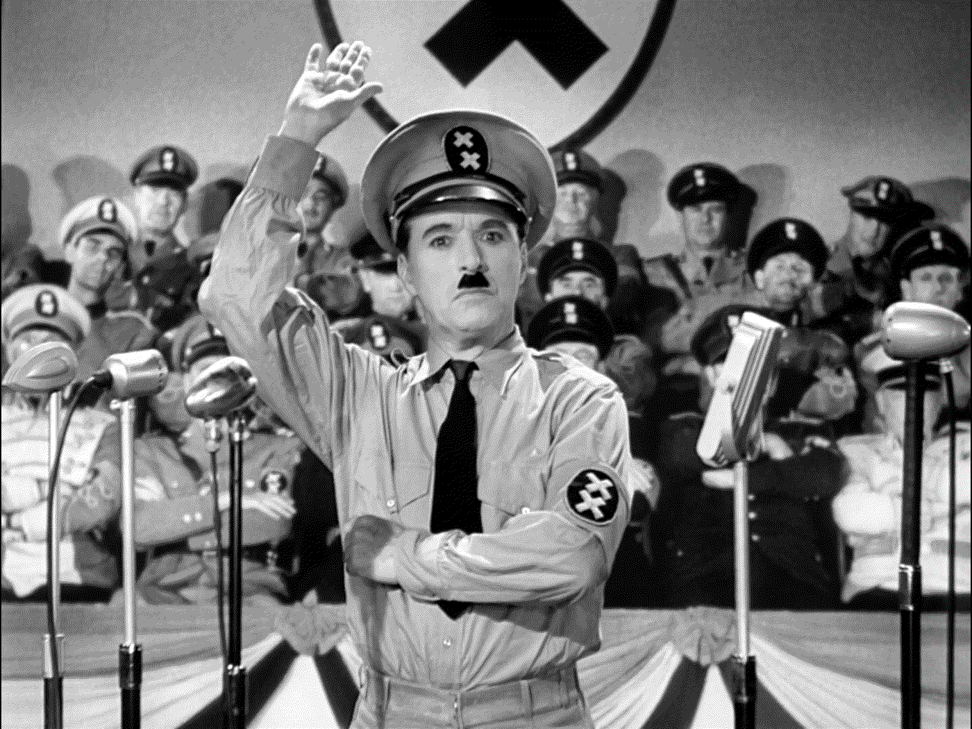 black and white filmstill of the movie "the great dictator" from Charlie Chaplin,where he is dressed up as Adolf Hitler