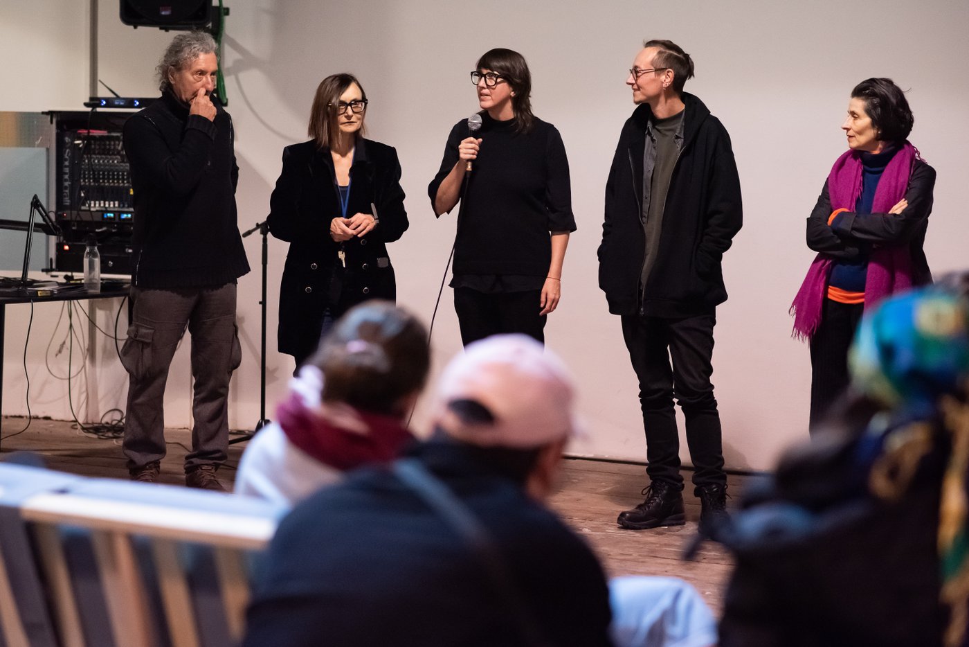 Two men and a woman give a spreach, the audience listens